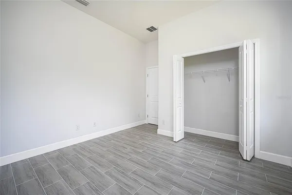 an empty room with wooden floor and closet