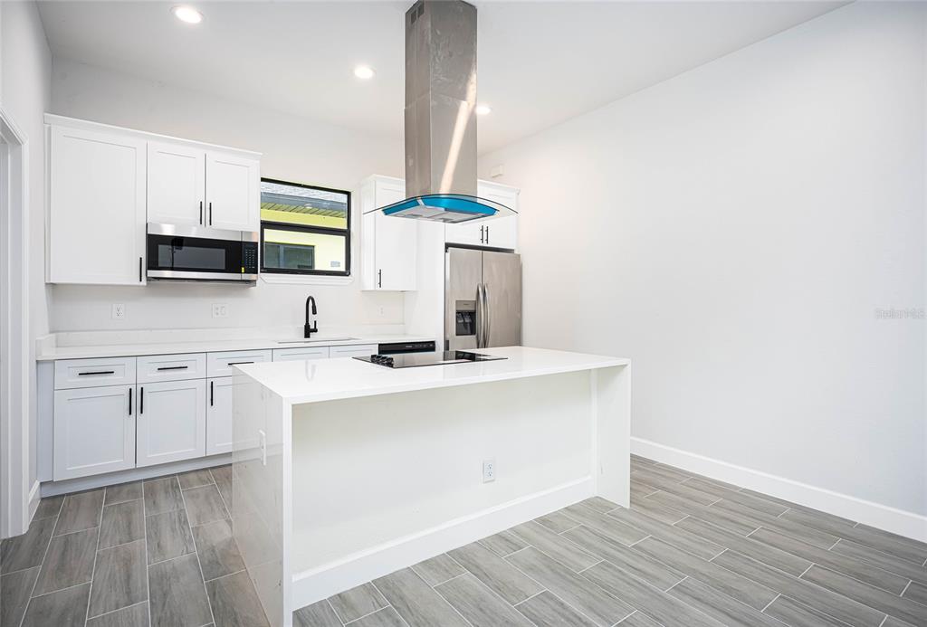 185 Sesame Road East Rotonda West, FL 33947 - Photo 14 of 60 a kitchen with stainless steel appliances a sink stove and cabinets