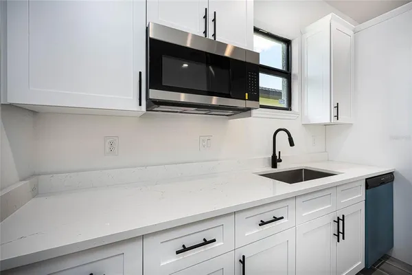 a kitchen with a sink stainless steel appliances and cabinets
