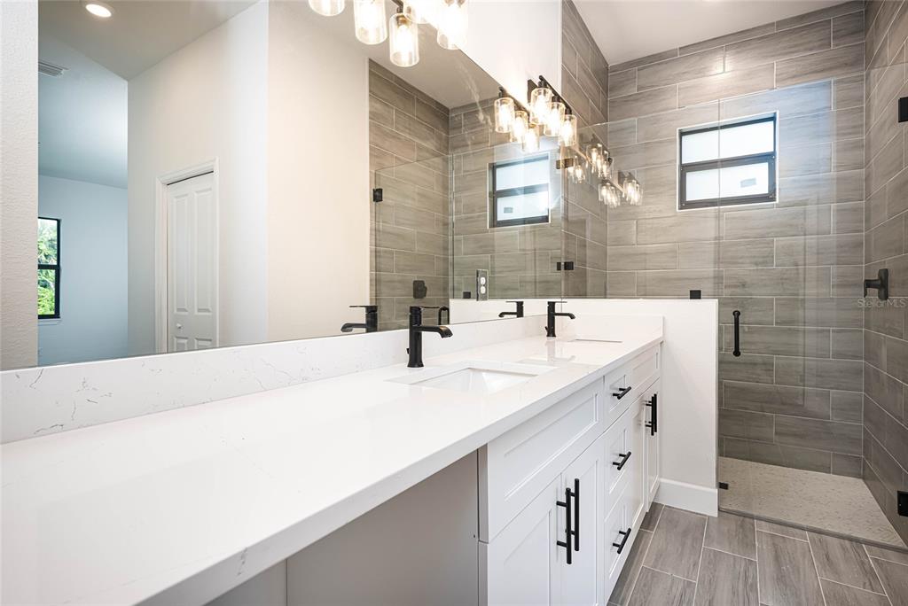 185 Sesame Road East Rotonda West, FL 33947 - Photo 32 of 60 a bathroom with a double vanity sink mirror and shower