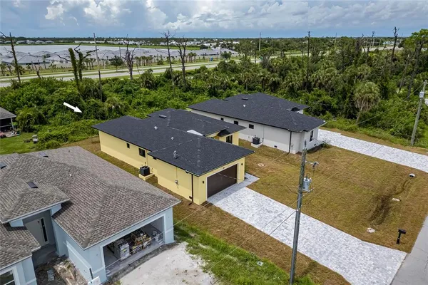 an aerial view of residential houses with outdoor space and trees