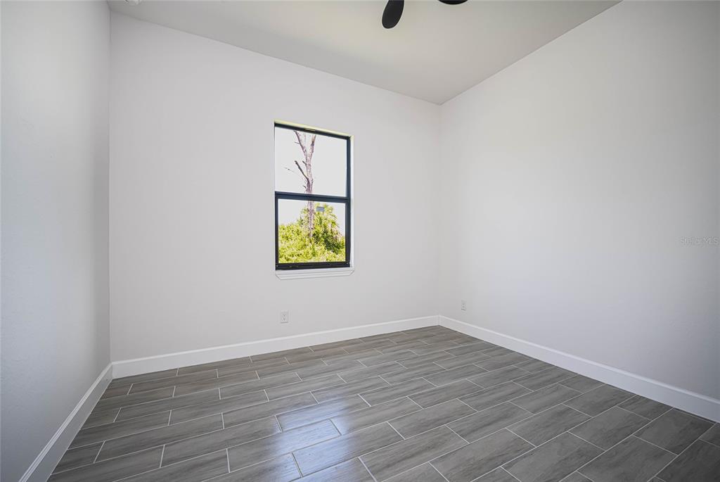 185 Sesame Road East Rotonda West, FL 33947 - Photo 9 of 60 a view of an empty room with wooden floor and a window