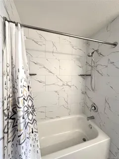 a bathroom with a bathtub and shower