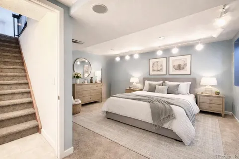 a spacious bedroom with a bed a mirror and vanity