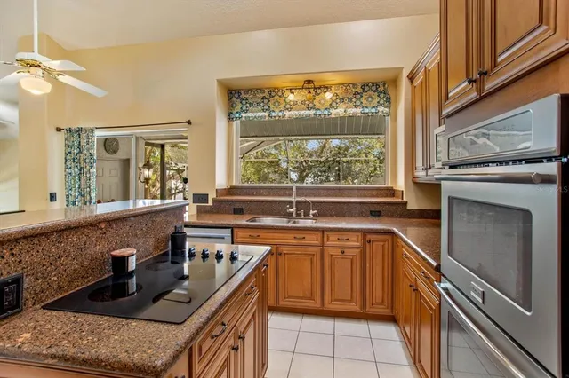 a kitchen with stainless steel appliances granite countertop a stove a sink and a microwave