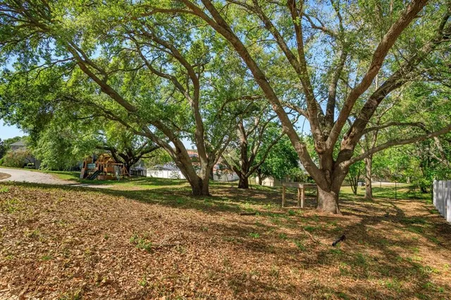 a backyard of a house with lots of green space and fountain