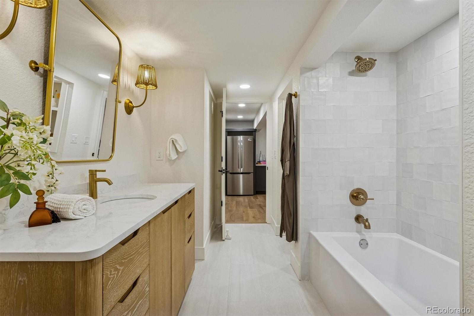 4872 Country Club Way Boulder, CO 80301 - Photo 35 of 48 a bathroom with a granite countertop sink a bathtub and a mirror