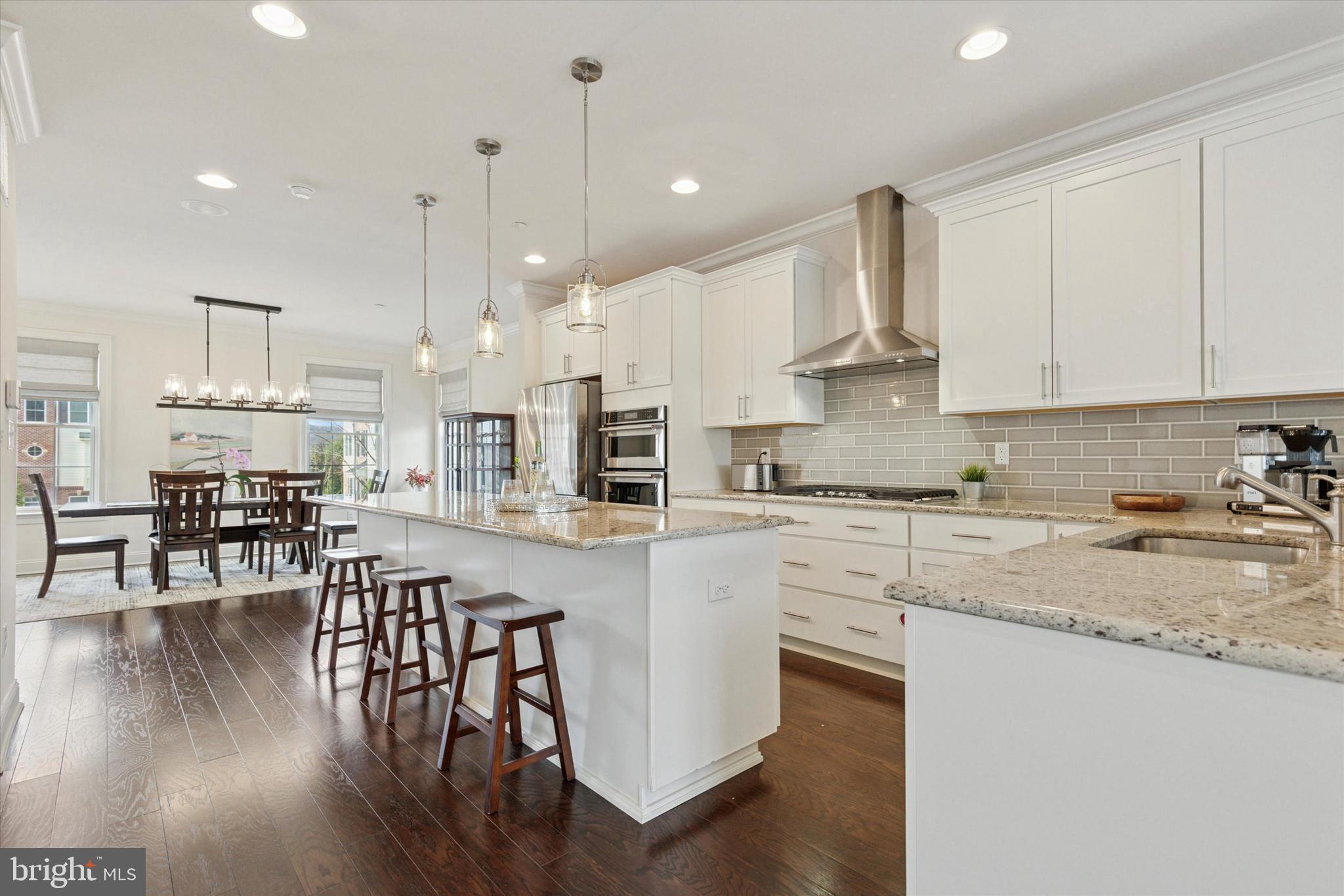 34 Parkview Cir. Wayne, PA 19087 - Photo 4 of 55 a kitchen with stainless steel appliances granite countertop a stove top oven a sink a refrigerator and white cabinets with wooden floor