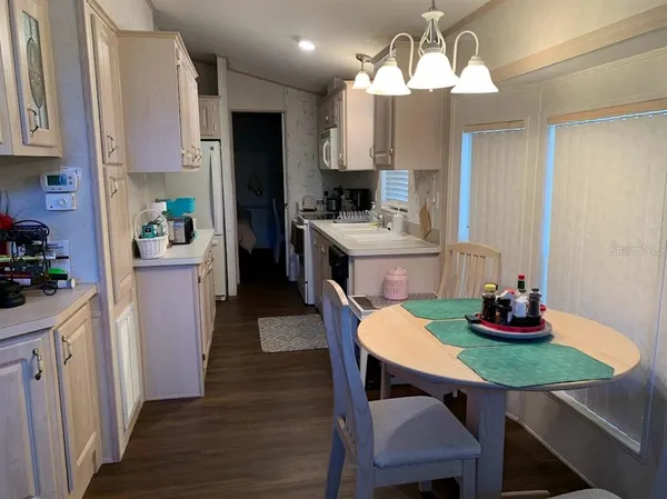 a kitchen with kitchen island a dining table and chairs