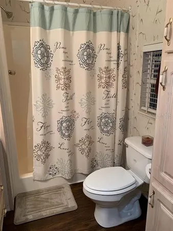 a bathroom with a toilet and a shower curtain