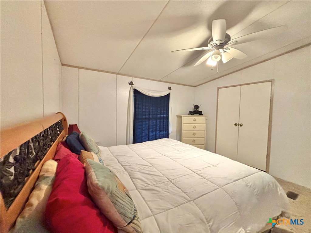 55 Scarlett Street Port O'Connor, TX 77982 - Photo 25 of 46 a bedroom with a large bed and a chandelier