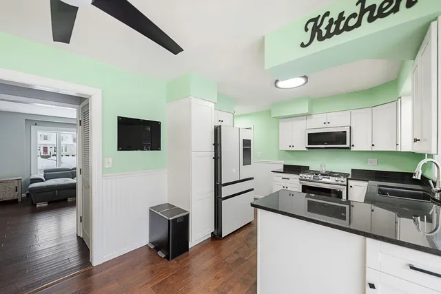 a kitchen with stainless steel appliances granite countertop a refrigerator a stove and a sink