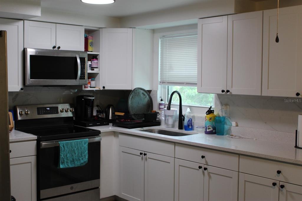 4928 Lake Ridge Lane Holiday, FL 34690 - Photo 4 of 7 a kitchen with a sink and cabinets