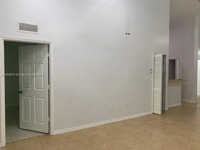 a close view of a refrigerator in kitchen and white cabinets