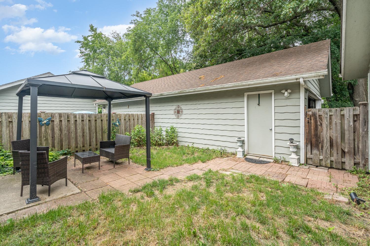 225 Clinton Street Lowell, IN 46356 - Photo 21 of 27 a backyard of a house with table and chairs under an umbrella