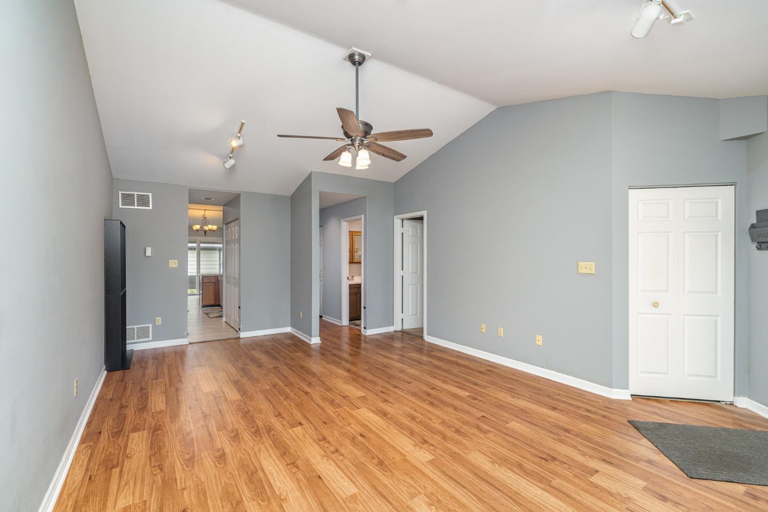 225 Clinton Street Lowell, IN 46356 - Photo 6 of 27 a view of a big room with wooden floor and a ceiling fan