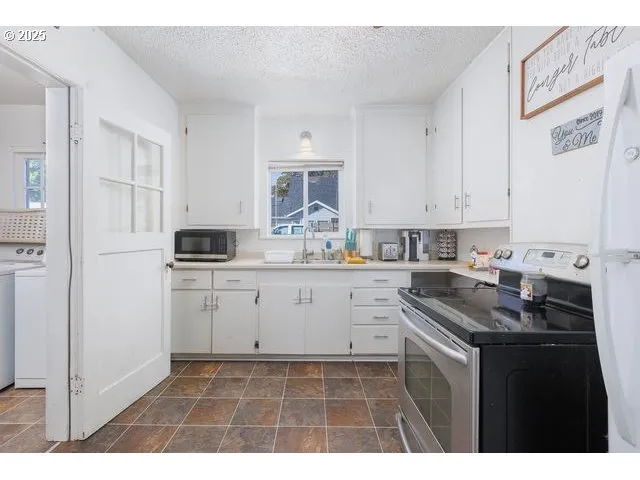 a kitchen with granite countertop a sink stove and cabinets