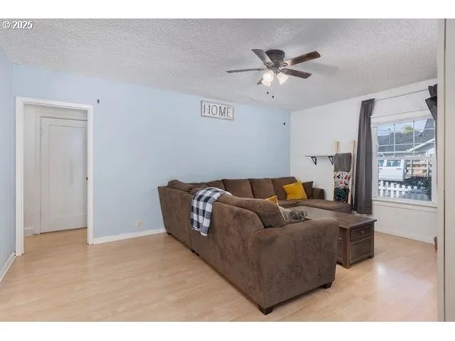 a living room with furniture and a ceiling fan