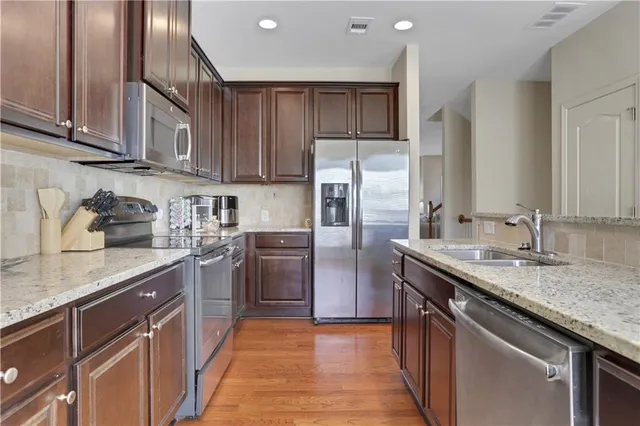 a kitchen with stainless steel appliances granite countertop a sink stove and refrigerator