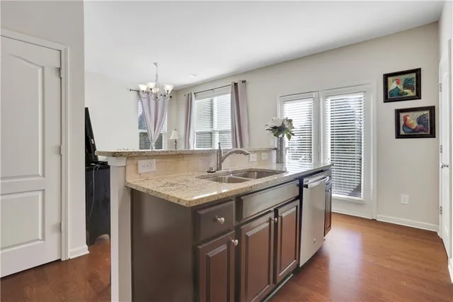 a kitchen with granite countertop a sink and a wooden floor