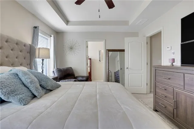 a bedroom with a large bed and a flat tv screen on dresser