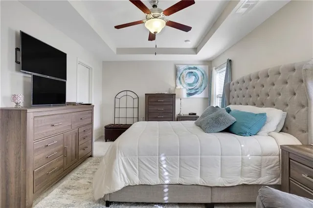 a bedroom with a bed and a flat tv screen on dresser