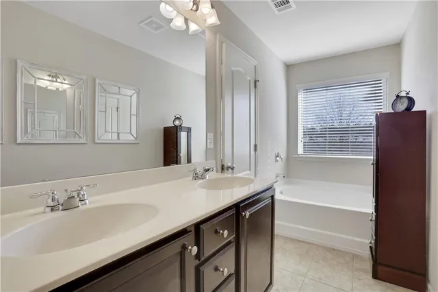 a bathroom with a sink double vanity granite tub shower and a mirror