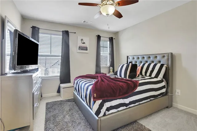a spacious bedroom with a bed and flat screen tv