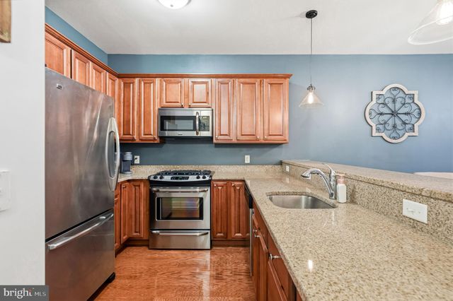 a kitchen with granite countertop a refrigerator stove and sink