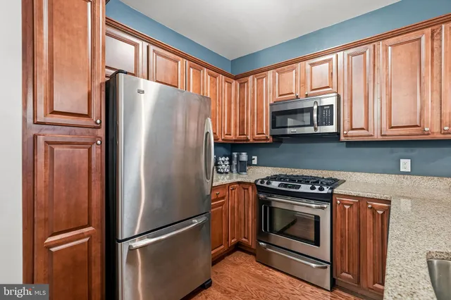 a kitchen with stainless steel appliances granite countertop a refrigerator stove and microwave