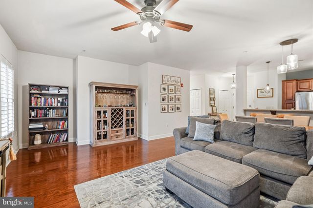 a living room with furniture and hard wood flooring