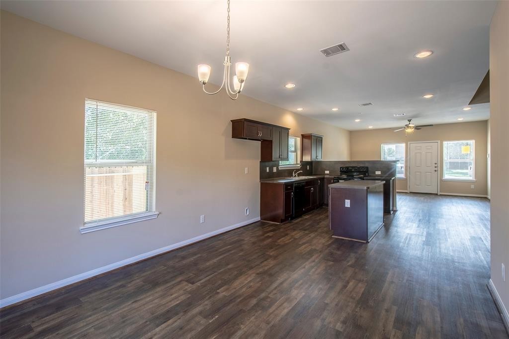 8142 Cabot Street, Unit A Houston, TX 77078 - Photo 4 of 21 a kitchen with stainless steel appliances granite countertop a stove top oven a refrigerator with island and wooden floor