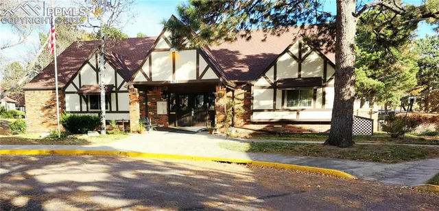 a view of a building with a patio and a yard