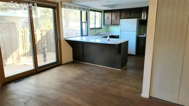 a view of a kitchen with a refrigerator and a window