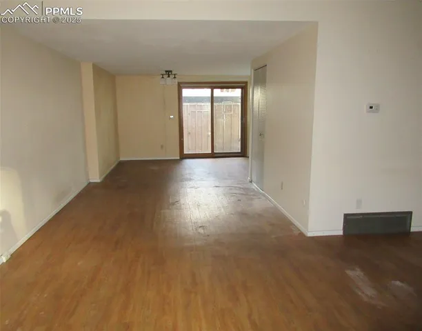 a view of a room with wooden floor and window