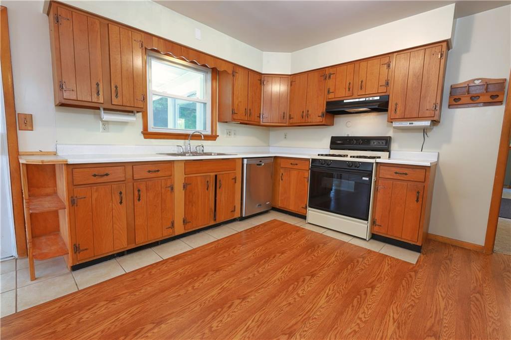 1311 19th Avenue Beaver Falls, PA 15010 - Photo 11 of 40 a kitchen with stainless steel appliances granite countertop a stove a sink dishwasher and a microwave oven with wooden floor