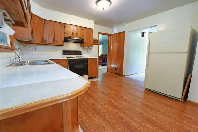 a kitchen with a refrigerator sink and wooden cabinets