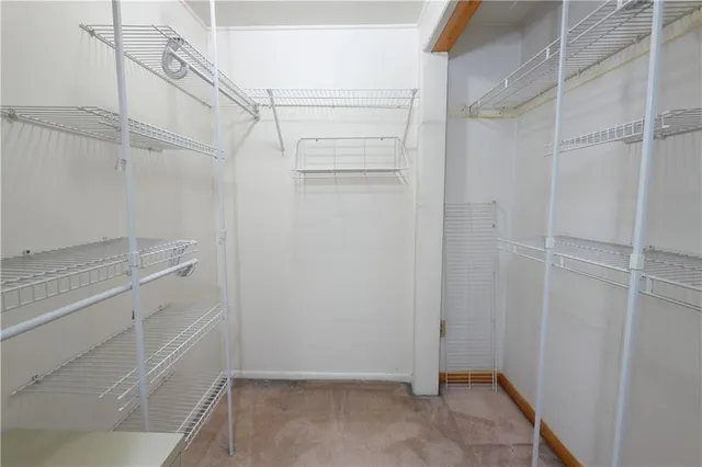 a view of an empty room with window and chandelier fan