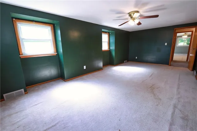 a view of a livingroom with a ceiling fan and window