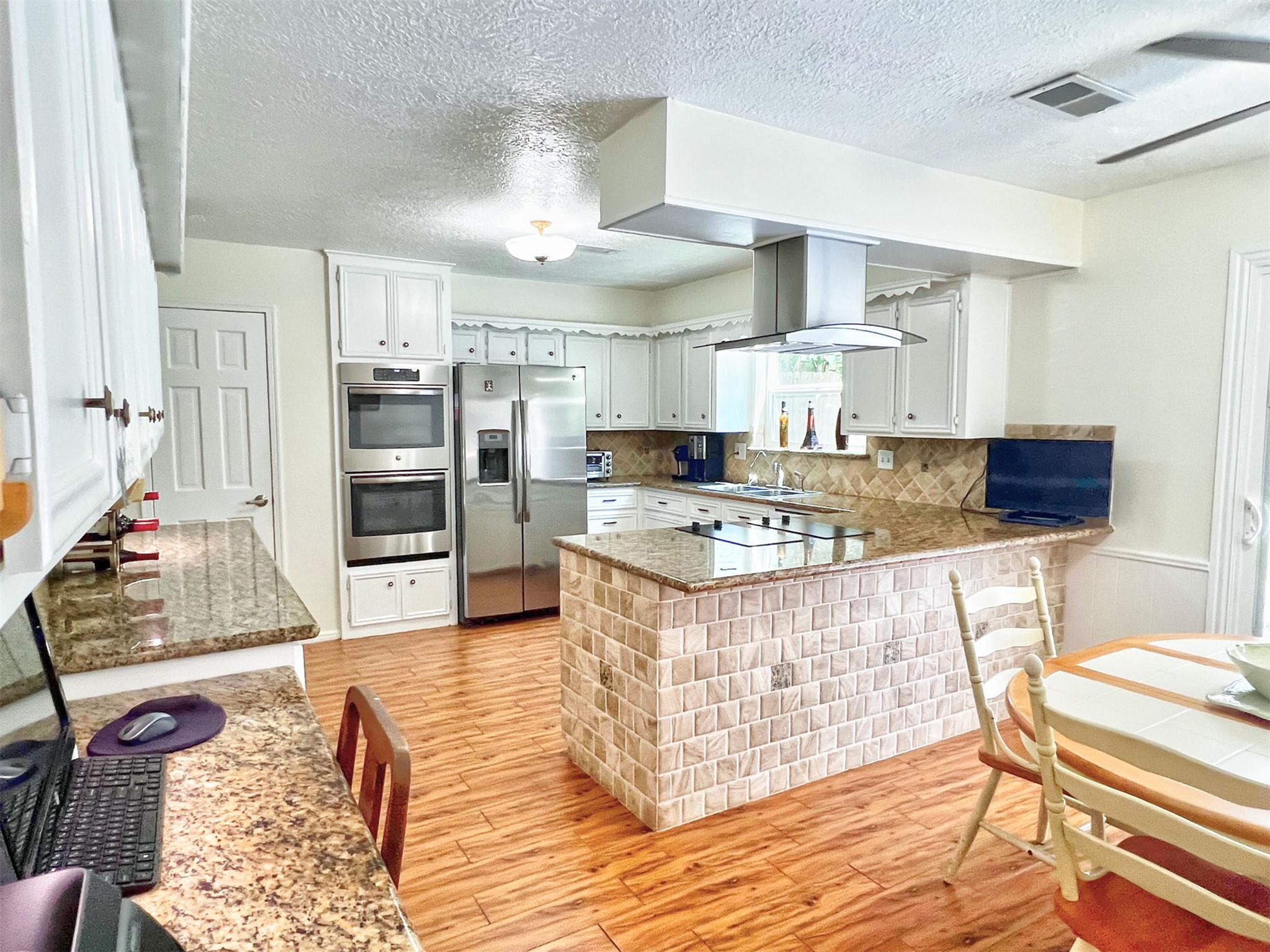 16902 Summit Oaks Lane Spring, TX 77379 - Photo 19 of 49 a kitchen with kitchen island granite countertop a stove and a wooden floors