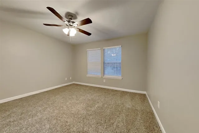 an empty room with window and ceiling fan