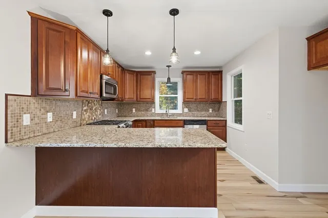 a kitchen with stainless steel appliances granite countertop a sink stove and microwave