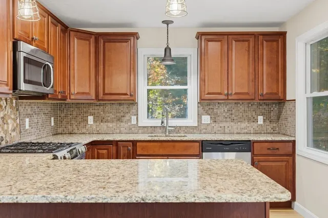 a kitchen with granite countertop wooden cabinets a stove top oven and a granite counter top