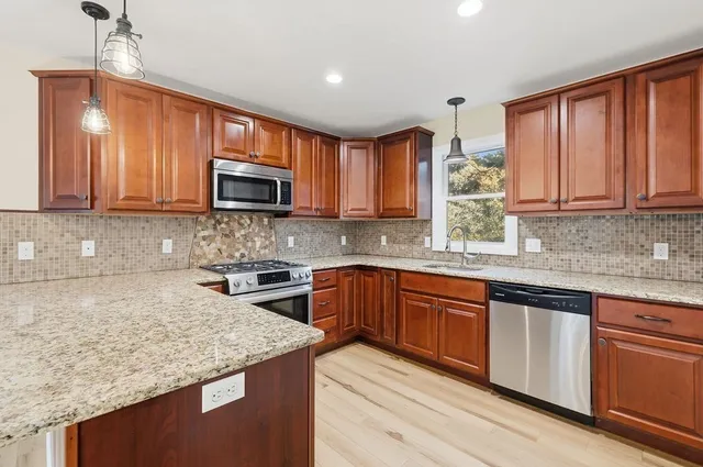 a kitchen with granite countertop a stove top oven microwave and cabinets