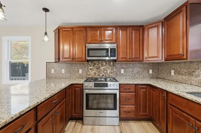 a kitchen with granite countertop wooden cabinets a sink and dishwasher