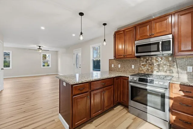 a view of an empty room and kitchen view