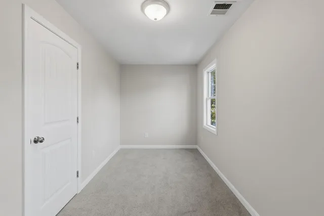 a view of an empty room with window and wall painting