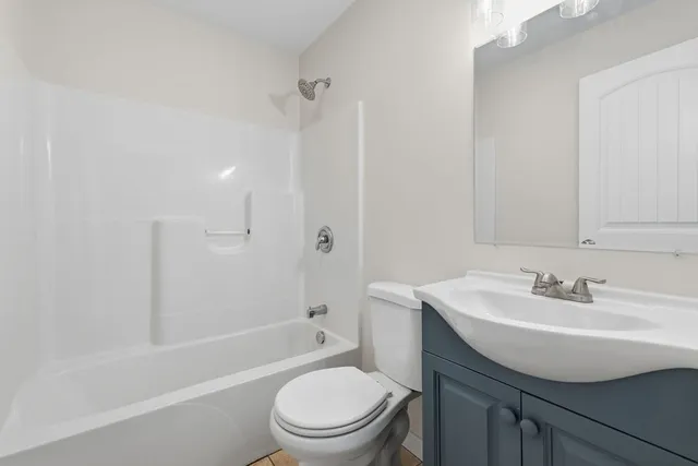 a bathroom with a toilet a sink a mirror and window