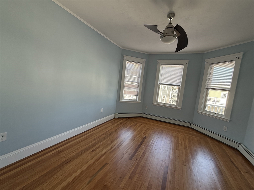 55 Lithgow Street, Unit 3 Boston, MA 02124 - Photo 12 of 16 a view of an empty room with wooden floor and a window
