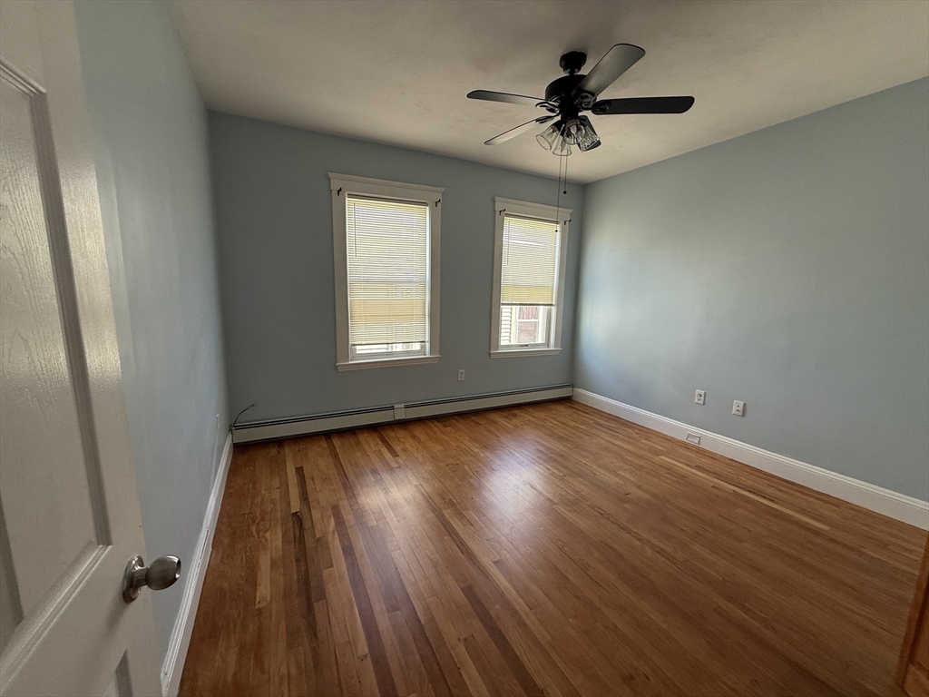 55 Lithgow Street, Unit 3 Boston, MA 02124 - Photo 14 of 16 wooden floor in an empty room with a window